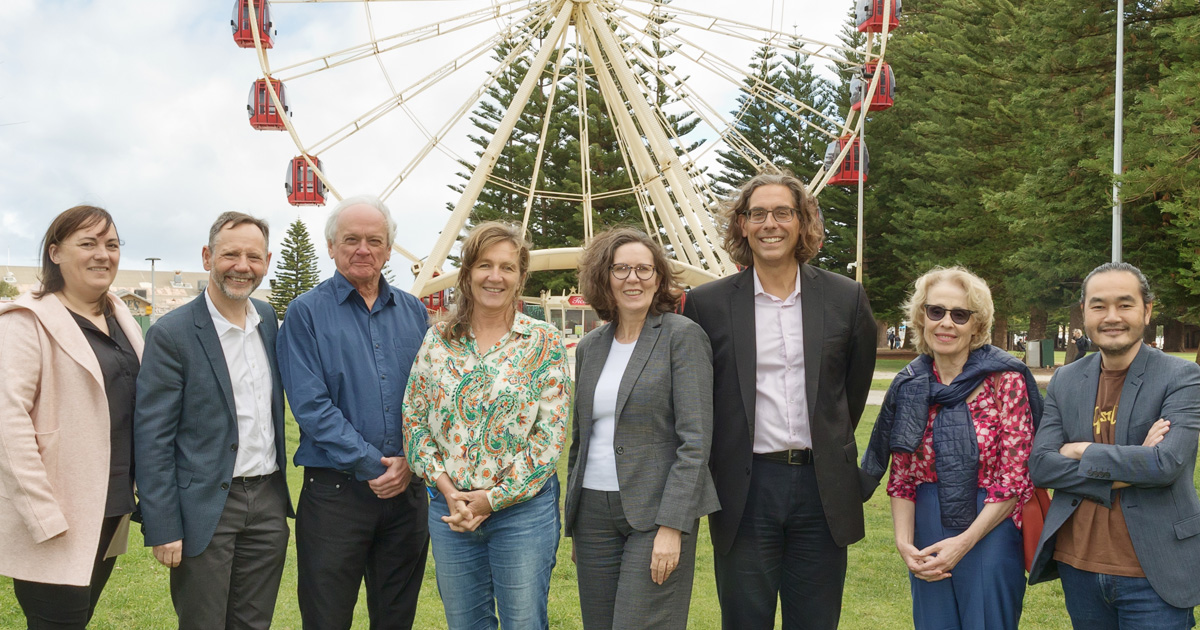 Eight researchers stand in a park 